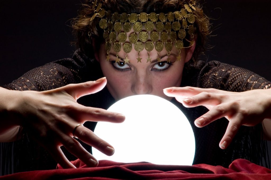 A gypsy fortune teller looks into a crystal ball